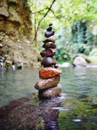 Stack of stones on rock by river