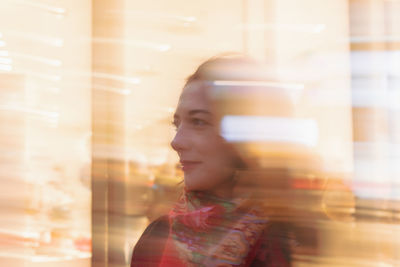 Thoughtful woman standing in illuminated city