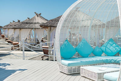 Lounge chairs by swimming pool against building