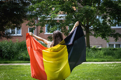 Portrait of a girl with a belgian flag in the park.