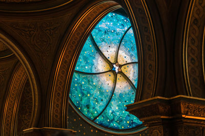 Low angle view of ornate stsined glass window in building
