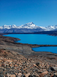 Scenic view of snowcapped mountains and lake against blue sky