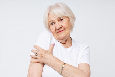 Portrait of smiling young woman gesturing against white background