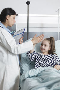 Doctor doing high five with patient in hospital