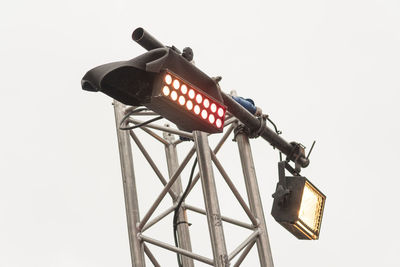 Low angle view of electric lamp against sky