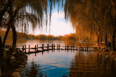 Wooden posts in lake against sky