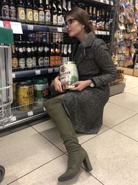 Full length of man drinking coffee at store