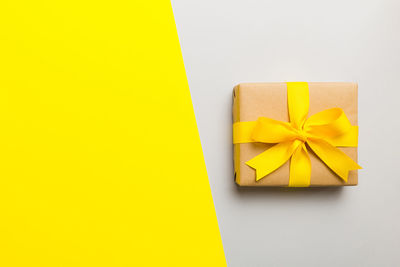 High angle view of gift box against yellow background