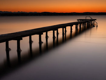 Scenic view of lake against orange sky