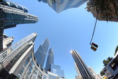 Low angle view of skyscrapers against blue sky