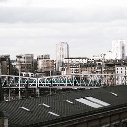 Modern buildings in city against cloudy sky