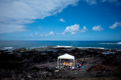 Scenic view of barbecue against sea and blue sky