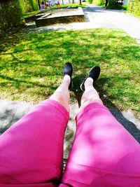 Low section of woman lying on grass in park