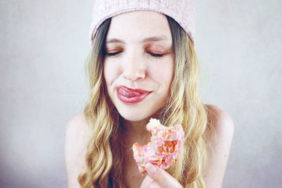 Close-up portrait of a smiling young woman holding ice cream