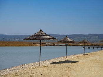 Gazebo by sea against clear blue sky