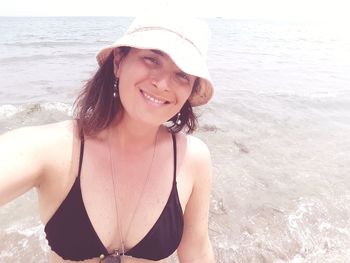 Portrait of smiling woman standing at beach