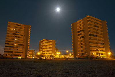 Low angle view of illuminated buildings against sky at night