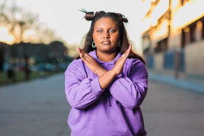 Portrait of young woman gesturing on road