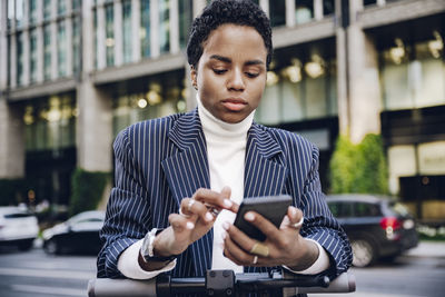 Young man using mobile phone in city