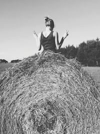 Woman standing on field against clear sky