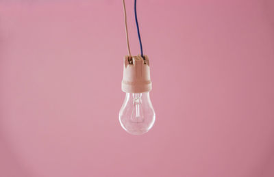 Temporary lighting, bulb on pink background