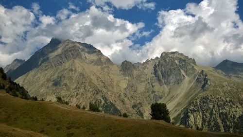 Panoramic view of mountain range against cloudy sky