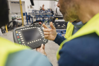 Engineer holding controller in robotics factory