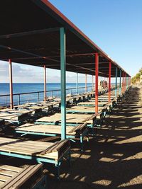 Empty chairs on beach against clear sky