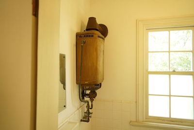 Close-up of electric lamp on wall at home