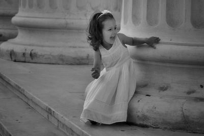 Happy girl standing by column