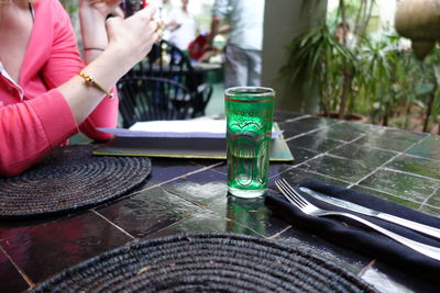 Close-up of woman drinking glasses on table