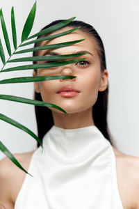 Portrait of young woman against white background