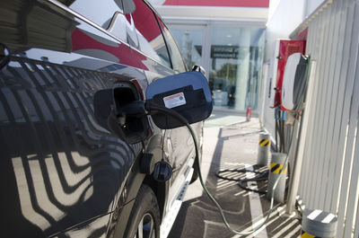 Close-up modern electric commercial van car plugged with fast charger at charging station. eco 