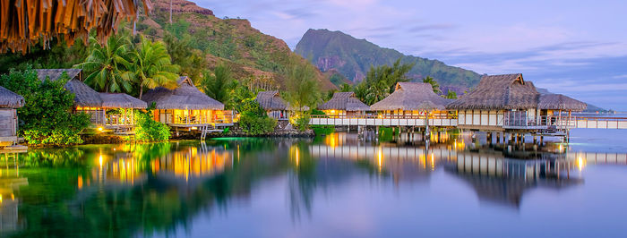 Scenic view of lake by buildings against sky