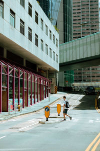 Woman on street against buildings in city