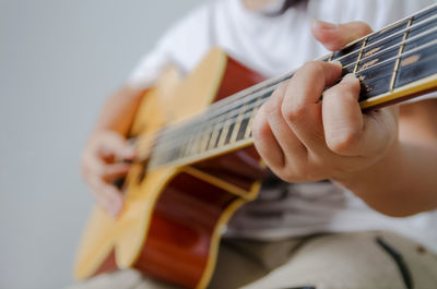 Midsection of person playing string instrument