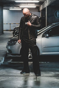 Full length of man standing by car at parking lot