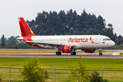 Airplane on airport runway against sky