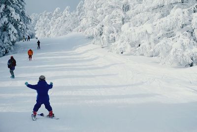 Rear view of boy skiing