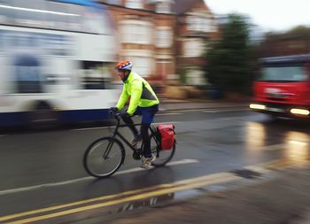 Man riding on wet road in city during rainy season