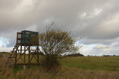 Traditional windmill on field against sky