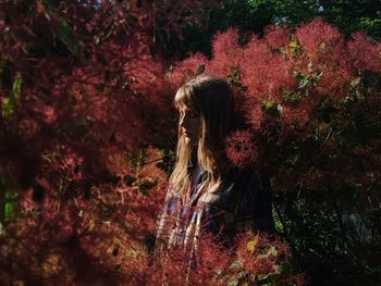 Woman standing by tree during autumn