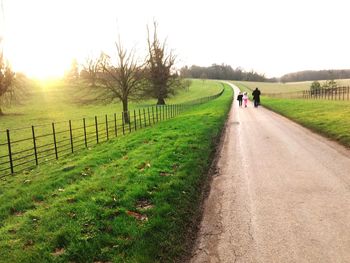 Road amidst field against sky