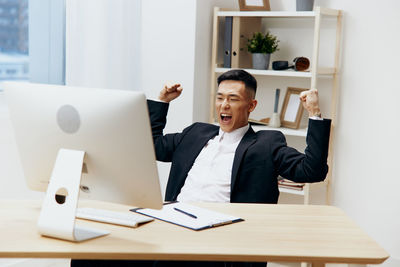 Portrait of businessman using laptop on table