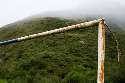 Rusty metallic structure on land against sky
