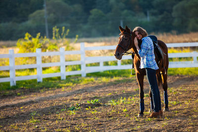 Full length of woman with horse on field