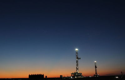 Illuminated factory against sky at night