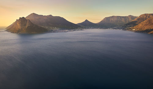 Scenic view of sea and mountains against clear sky