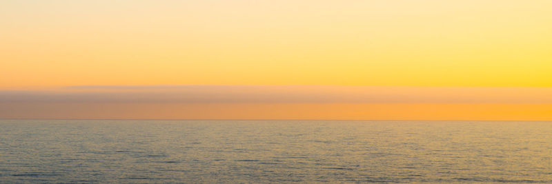 Scenic view of sea against clear sky during sunset