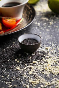 High angle view of sesame seeds in bowl and stone stray